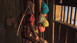 Naoe stands before a group of colourful bags that represent scouts in Assassin's Creed Shadows.